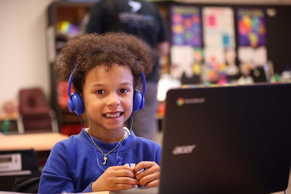 student in classroom smiling at camera